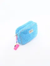 Necessaire de textura tipo felpa o chenille en color celeste, con cierre perimetral y etiqueta frontal de la marca Common Wear. Incluye un detalle de cadena plástica multicolor con una placa rosa colgante en el lateral.