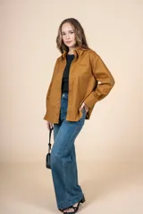 Camisa marrón de corte clásico, con tejido suave y textura cálida. Tiene un bolsillo decorativo discreto y botones al tono.