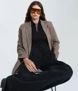 Pantalón de corte wide leg confeccionado en algodón con felpa, color marrón topo. Presenta cintura elástica con cordón ajustable y costuras verticales decorativas en el frente.