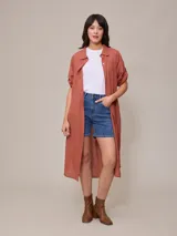 Vestido camisero largo de corte holgado, con cuello clásico, cierre frontal completo con botones y mangas tres cuartos.