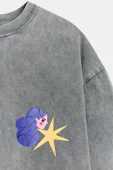 Camiseta de corte oversize con efecto lavado, cuello redondo y manga corta. Presenta un estampado pequeño a contraste en el pecho que representa una figura femenina con una estrella.