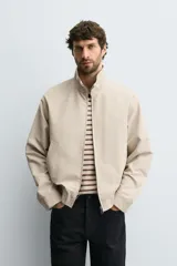 Cazadora regular fit de algodón color beige, con cuello subido, cierre frontal de cremallera y bolsillos laterales de vivo.