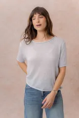 Buzo liviano de tejido de punto color celeste, con escote redondo, mangas cortas y terminaciones con bordes enrollados.