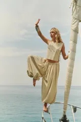 Top corto color beige de bambula con escote redondo, sisas amplias y tiras laterales para atar.