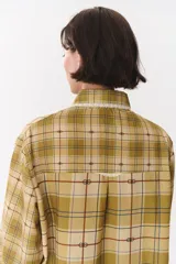 Camisa de corte holgado en color bordó con estampado de cuadros y monograma. Presenta cuello redondo con borde de puntilla, bolsillo frontal con detalle de puntilla, cierre frontal con botones y puños con terminación en puntilla.