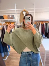 Capa tejida de punto en color verde oliva, con diseño cruzado en el frente y mangas tipo murciélago de calce holgado.