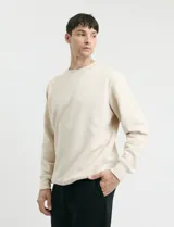 Sweater básico de cuello redondo y manga larga, confeccionado en tejido circular con puños y cuello en tejido canalé.