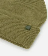 Gorro de punto de estilo beanie, color bordó, con borde plegado y etiqueta decorativa aplicada.