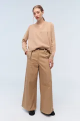 Sweater de tejido de punto color beige, con escote en V y calce holgado.