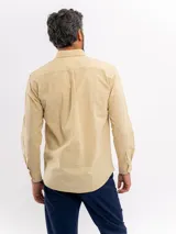 Camisa de manga larga con efecto lino, color azul, cuello con botones y bolsillo ojal en el pecho.
