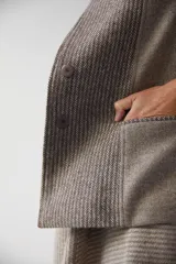 Chaqueta corta color marrón con cuello solapa y diseño con patchwork de telas. Manga larga con detalle de coderas aplicadas. Cierre frontal mediante botones y bolsillos ojal. Con forro.