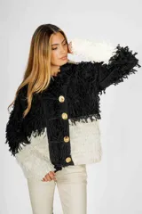 Saco negro con textura de lana, corte recto, con botones dorados y diseño con flecos.