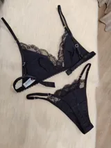 Conjunto de lencería compuesto por un bralette triangular de algodón con detalles de encaje en los bordes y una bombacha colaless a juego con detalles de encaje laterales.