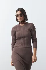 Sweater de tejido tipo rib, color negro, con cuello redondo y mangas largas. Presenta una textura acanalada y un ajuste al cuerpo.