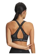 Top deportivo de soporte medio con diseño de espalda cruzada. Presenta un estampado jaspeado en tonos negros y grises, con una banda elástica inferior negra que incluye el logo de la marca en letras blancas. Confeccionado en tejido HeatGear de doble capa, de secado rápido y alta transpirabilidad.