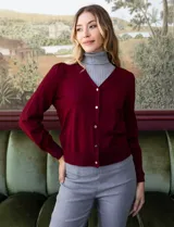 Cardigan rojo tejido en hilado fino, con escote en V y abertura central con botones metálicos.