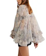 Blusa de chiffon con estampado floral en tonos pastel y grisáceos. Presenta escote en V con cierre frontal de botones nacarados, mangas largas amplias con puños con volados y un ruedo con volado en el bajo.