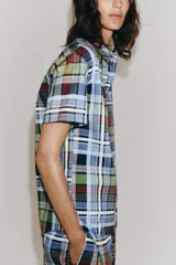 Camisa de manga corta de algodón, con cuello de solapa, cierre frontal de botones y bajo recto, con estampado de cuadros multicolores.