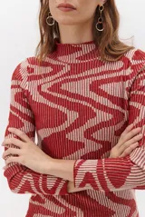 Polera de tejido de punto con diseño vanizado que combina tonos tierra y crema en un patrón abstracto de líneas onduladas. Presenta cuello alto, mangas largas y un ajuste entallado al cuerpo.