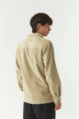 Sobrecamisa de pana color beige, con cuello clásico, cierre frontal de botones y bolsillos tipo cartera en el pecho.