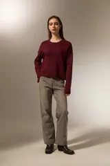 Sweater de punto negro con destellos de lurex, cuello redondo a la base y mangas largas con puños ajustados.