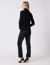 Polera de tejido fino, color rosado, con cuello alto, manga larga y detalle de tajo en los puños.