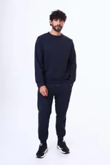 Buzo de felpa color negro, con cuello redondo, mangas largas y puños elásticos. Diseño básico y minimalista.