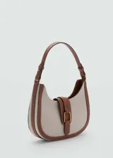 Bolso tipo hobo de lona color crema con ribetes de cuero marrón y cierre con hebilla dorada.