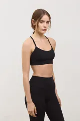 Top deportivo negro de compresión media, con escote redondo clásico, tiras finas cruzadas en la espalda y tazas intercambiables.