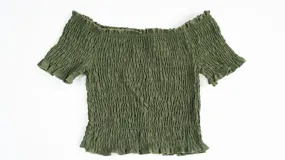 Top de color azul con diseño fruncido en toda la prenda, escote estilo hombros caídos y mangas cortas con terminación de volados.