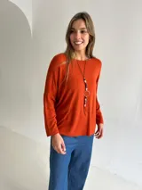 Sweater de tejido de punto color naranja oscuro, con cuello redondo, mangas largas y diseño holgado con caída fluida.