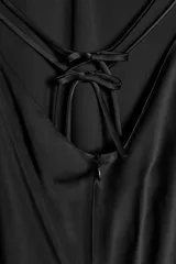 Vestido largo color rosa pálido, con escote en V pronunciado y tirantes finos tipo espagueti que se unen en la espalda. El corte es recto y holgado, con caída fluida.