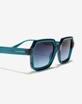 Gafas de sol Hawkers unisex, modelo Minimal Max, con montura octogonal de acetato color azul petróleo y lentes degradadas en azul.