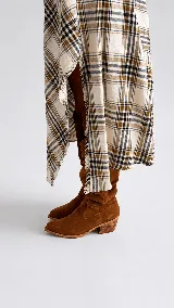Bota tejana de caña media, confeccionada en gamuza color tostado, con diseño holgado y taco cuadrado de madera.