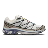 Championes Salomon XT-6, calzado de trail running adaptado para uso urbano. Diseño en color blanco con detalles en beige, negro y azul, con sistema de cordones de ajuste rápido Quicklace y suela de gran tracción.