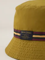 Gorro tipo bucket verde con cinta decorativa azul y amarilla.