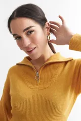 Vestido corto negro de tejido de punto acanalado, con mangas largas y medio cierre frontal.