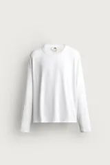 Remera manga larga blanca de corte relaxed fit, con cuello redondo y diseño liso de algodón.