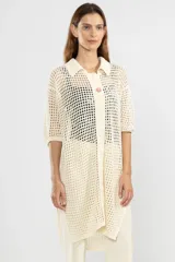 Camisa larga de punto abierto color crema, con cuello clásico, manga corta y cierre frontal con botones.