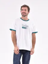 Remera blanca de mangas cortas con cuello y puños en color verde. Estampado frontal con texto y pelotas de tenis.