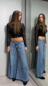Jean de denim celeste de tiro bajo, con diseño flare de corte ancho en las piernas, costuras frontales destacadas y terminación desmechada en el ruedo.