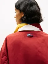 Campera de nailon con diseño color block en rojo, amarillo y azul marino. Tiene cuello alto, cierre de cremallera oculto con botones a presión, puños y bajo elásticos, dos bolsillos ribeteados en la cintura y logo de Tommy Hilfiger en la parte delantera, la trasera y las mangas.