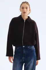 Campera corta marrón oscuro de mezcla de lana, con cuello camisero, cierre frontal plateado, bolsillos ribeteados y cordón ajustable en el bajo con dobladillo fruncido. Diseño oversized con hombros caídos y mangas largas.