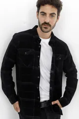 Camisa de pana en color azul marino con diseño de cuadros sutiles, manga larga, cuello clásico y dos bolsillos frontales con solapa y botón.