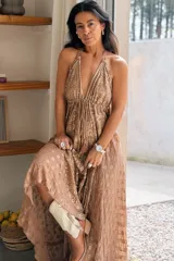 Vestido largo tostado con bordado artesanal y apliques de glitter, tirantes finos ajustables con cuello halter y escote en V con cordón ajustable en el pecho.