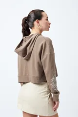 Canguro cropped negro con cierre frontal y estampa abstracta en contraste en las mangas.