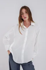 Camisa clásica de manga larga en color bordó, confeccionada en tela ligera con caída fluida, cuello camisero y cierre frontal con botones al tono.