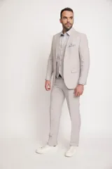 Ambo de corte comfort fit confeccionado en una mezcla de lino, viscosa y poliéster. El conjunto incluye un saco de dos botones con bolsillos laterales y un pantalón de corte recto, ofreciendo una textura suave y mayor resistencia a las arrugas que el lino tradicional.