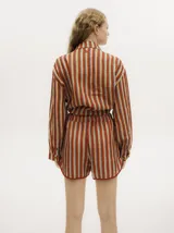Short de lino sublimado con estampado a rayas en tonos tostado, rojo y celeste, de corte estilo bóxer con pretina elástica.