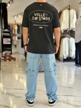 Remera blanca oversize con estampado gráfico en la espalda con la inscripción "Valley of Stars", diseño de manga corta y corte holgado.
